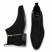 Black suede zip ankle boots, three-quarter angle showing side zipper and heel