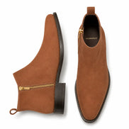 Tan suede zip boot, three-quarter angle showing side zip, heel and sole detailing