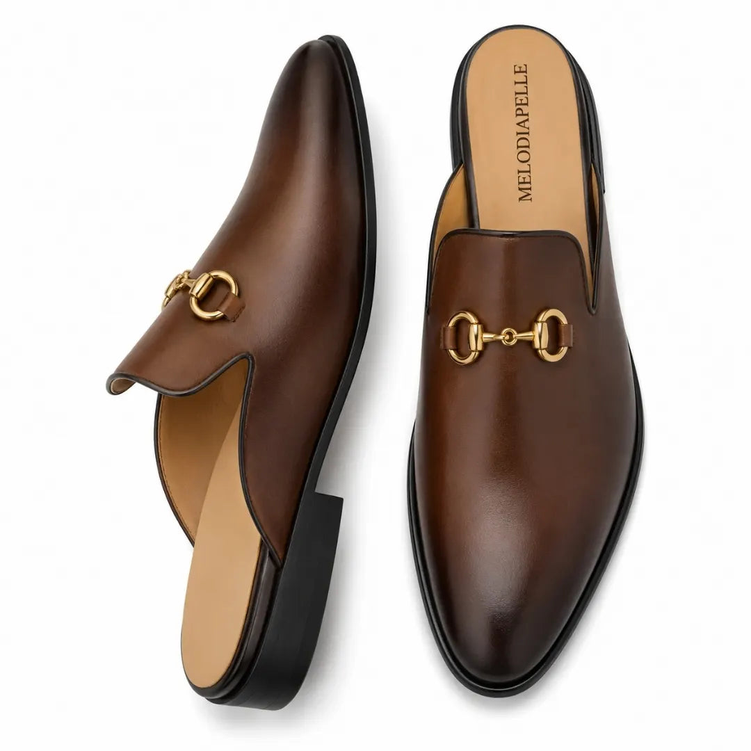 Brown leather horsebit mule, three-quarter angle showing buckle and heel