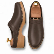 Dark brown leather backless mule, three-quarter angle showing heel and sole detailing