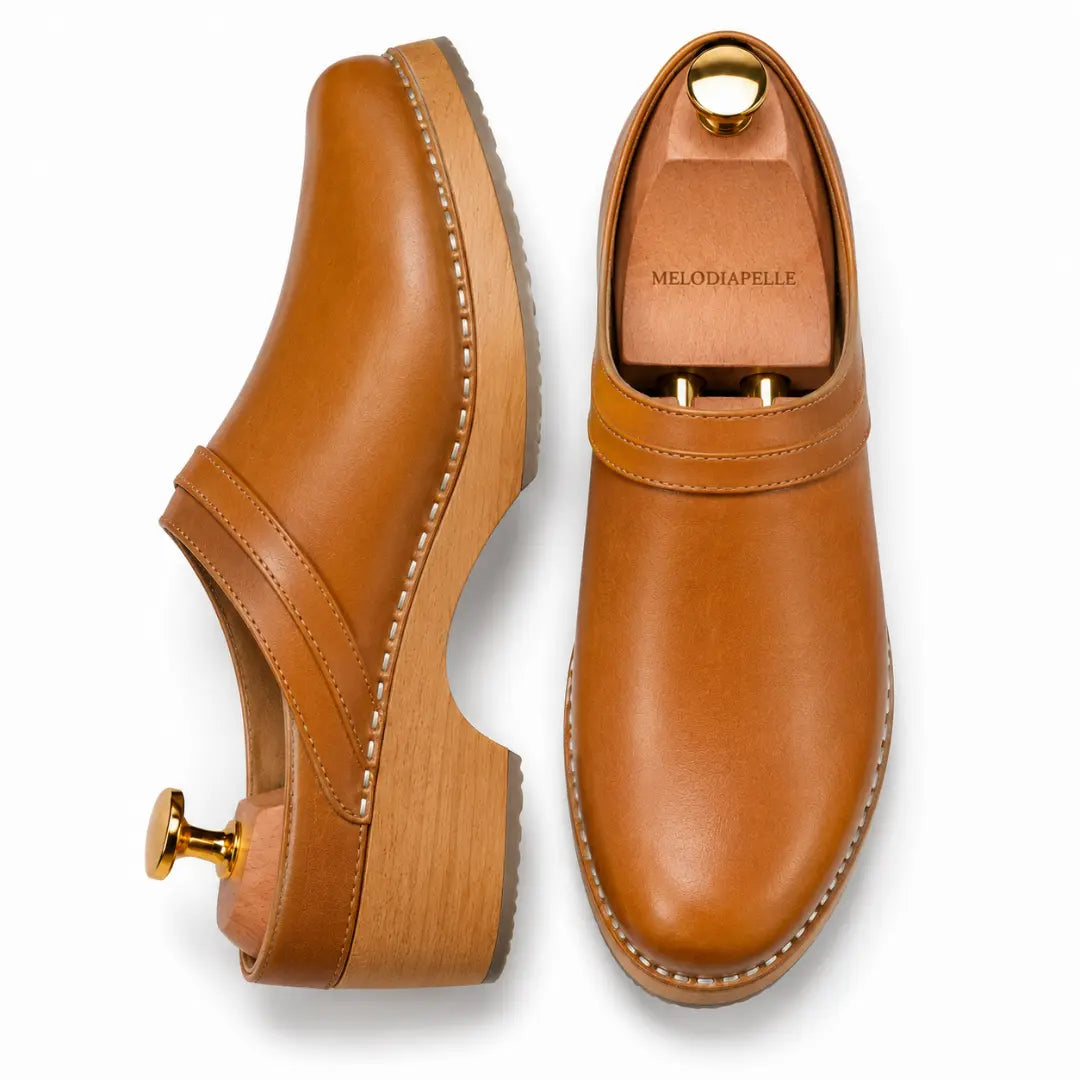 Tan leather backless mule, three-quarter angle showing heel and sole detailing