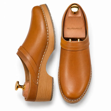 Tan leather backless mule, three-quarter angle showing heel and sole detailing