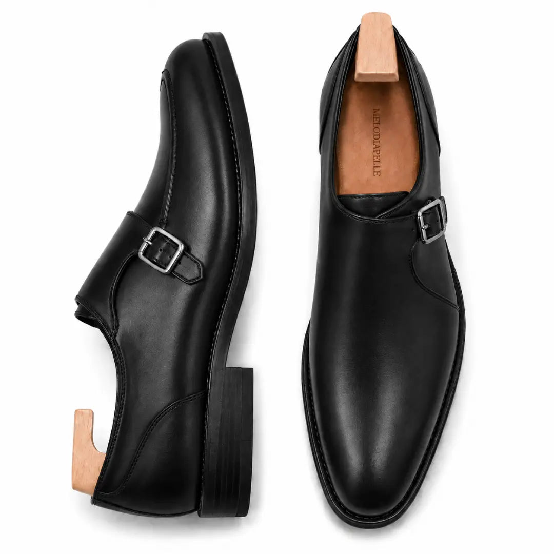 Black leather single monk strap shoe, three-quarter angle showing buckle and heel