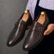Man holding a pair of Melodiapelle Madrid Single Monk Strap shoes in dark chocolate leather, close-up