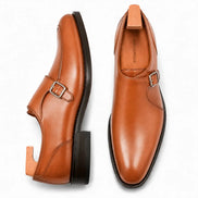 Tan leather single monk strap shoe, three-quarter angle showing buckle and heel