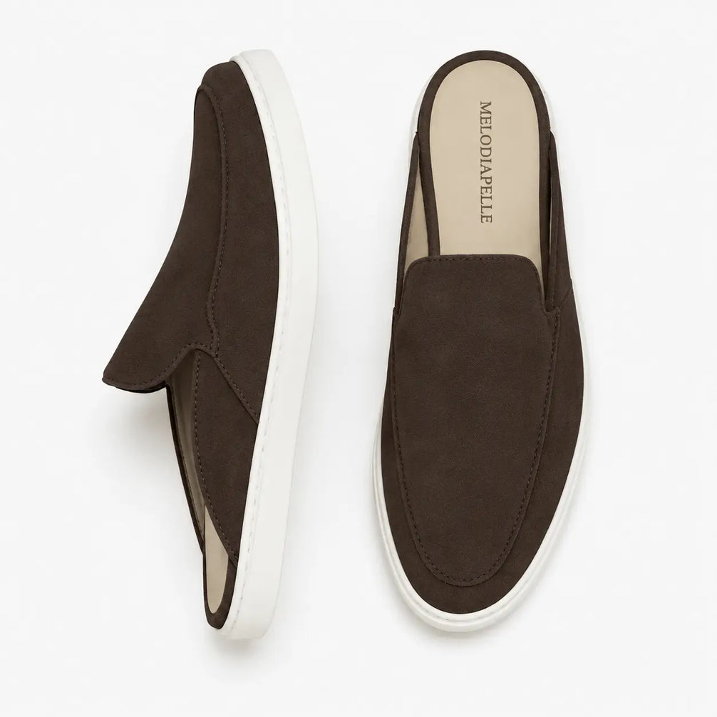 Dark brown suede mule with white sneaker-sole, three-quarter angle showing heel and sole detailing