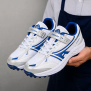 Man holding a pair of Melodiapelle Maduro Cricket Shoes in white and royal blue, close-up
