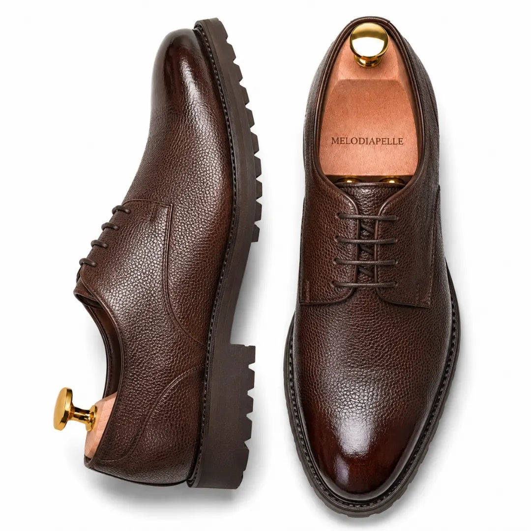 Dark brown leather plain-toe Derby, three-quarter angle showing heel and sole detailing