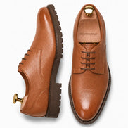 Tan leather plain-toe Derby, three-quarter angle showing heel and sole detailing