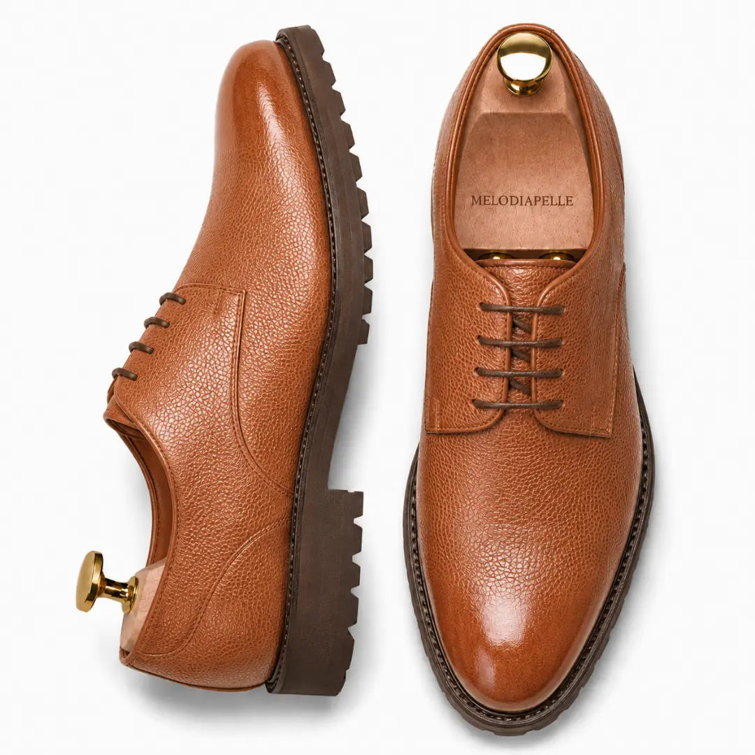 Tan leather plain-toe Derby, three-quarter angle showing heel and sole detailing