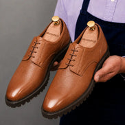 Man holding a pair of Melodiapelle Magnum Derby Shoes in tan leather, close-up