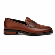 Side profile of the Maison Woven Penny Loafer in cognac tan leather on white background