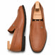 Tan leather driving loafer, three-quarter angle showing moc-toe stitching and heel