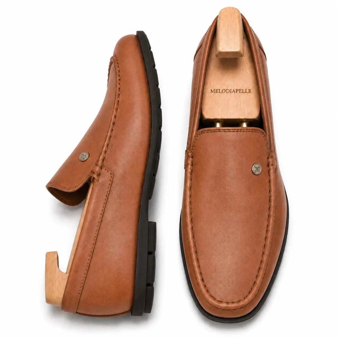 Tan leather driving loafer, three-quarter angle showing moc-toe stitching and heel