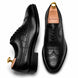 Black leather wingtip Derby, three-quarter angle showing croc-embossed panel and heel