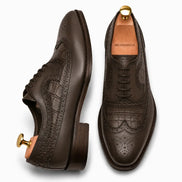 Brown leather wingtip Derby, three-quarter angle showing croc-embossed panel and heel