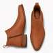 Tan leather ankle boot, three-quarter angle showing side zip and heel detailing