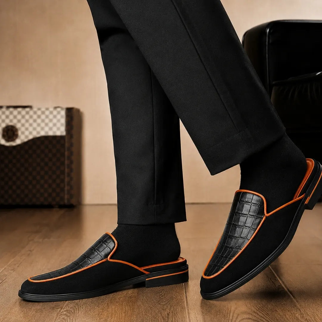 Melodiapelle Malta Mule in black croc-embossed leather with orange piping worn with formal trousers, on-feet shot