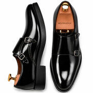 Black leather double monk strap shoe, three-quarter angle showing buckles and heel