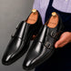 Man holding a pair of Melodiapelle Manchester Monk Strap shoes in black leather, close-up