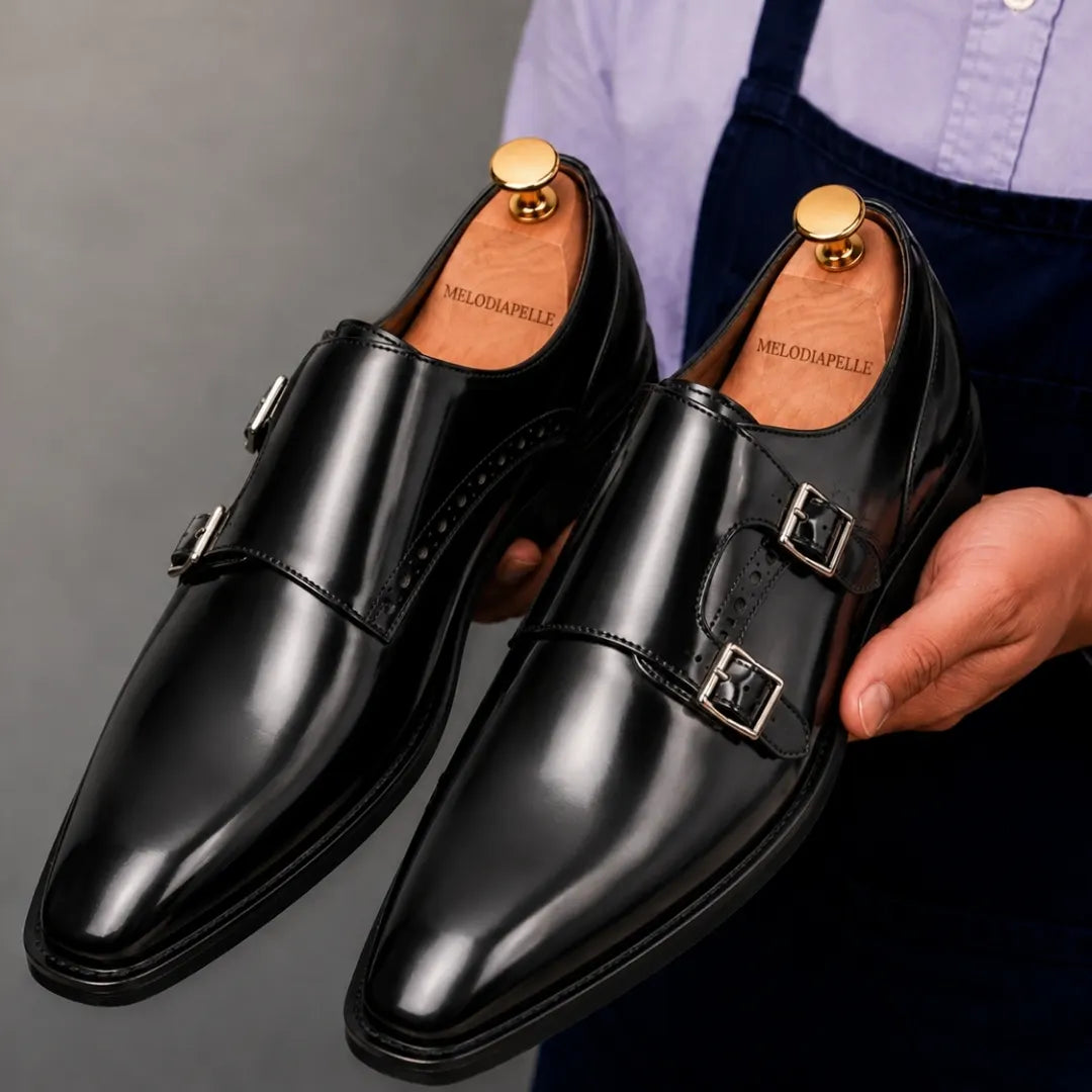 Man holding a pair of Melodiapelle Manchester Monk Strap shoes in black leather, close-up