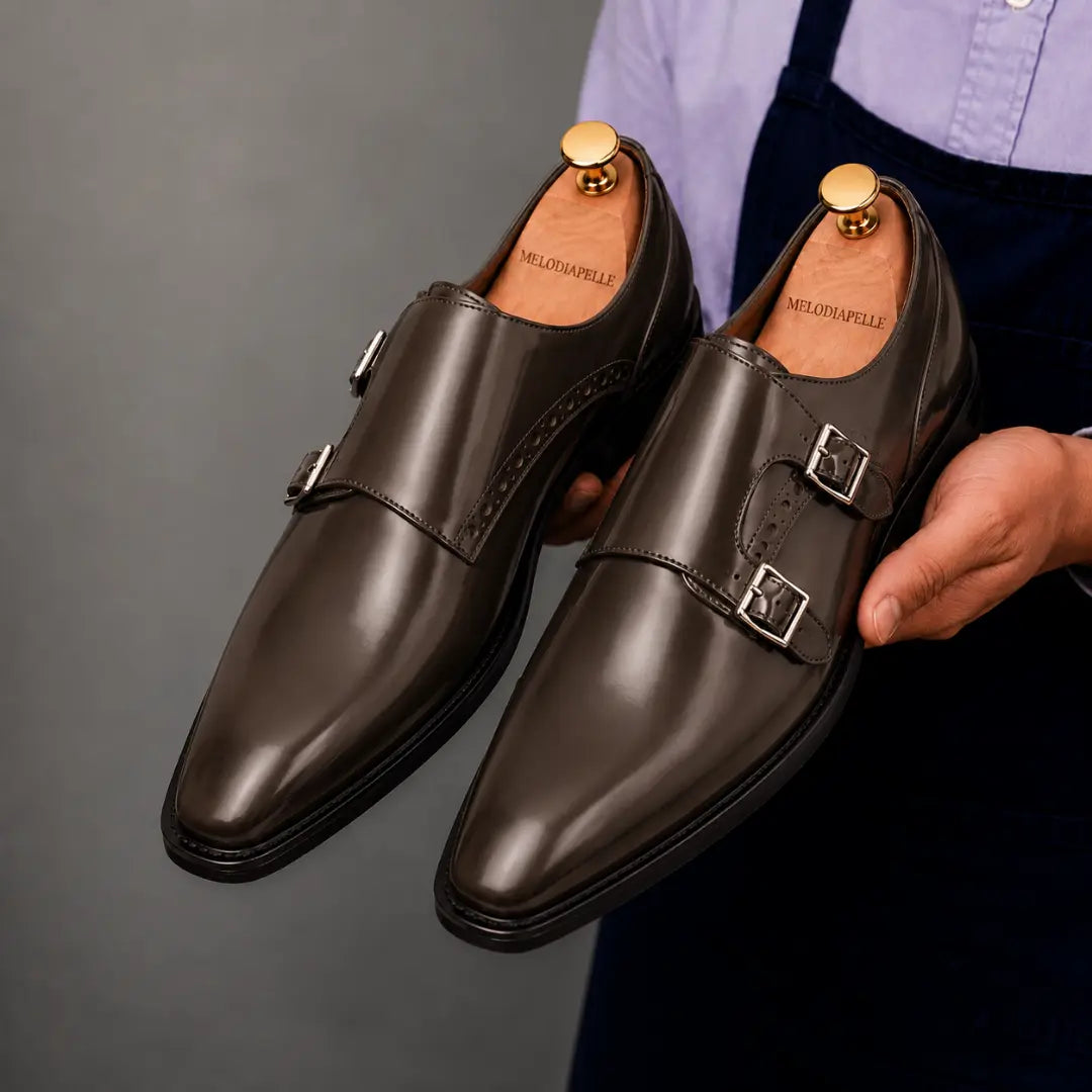 Man holding a pair of Melodiapelle Manchester Monk Strap shoes in brown leather, close-up