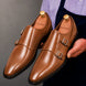 Man holding a pair of Melodiapelle Manchester Monk Strap shoes in tan leather, close-up