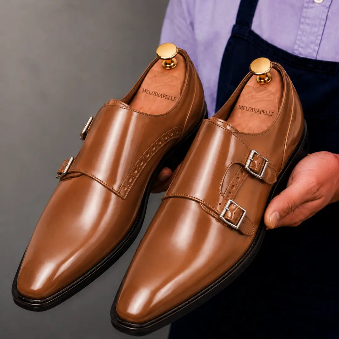 Man holding a pair of Melodiapelle Manchester Monk Strap shoes in tan leather, close-up