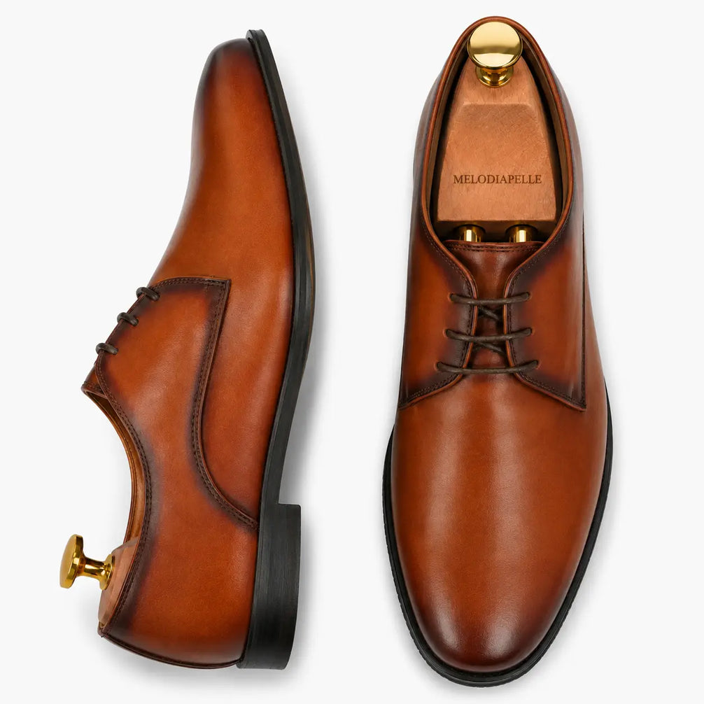 Cognac tan leather plain Derby, three-quarter angle showing heel and Goodyear-welted stitching