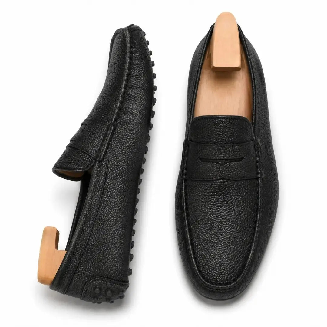 Black leather penny loafer, three-quarter angle showing sole detailing