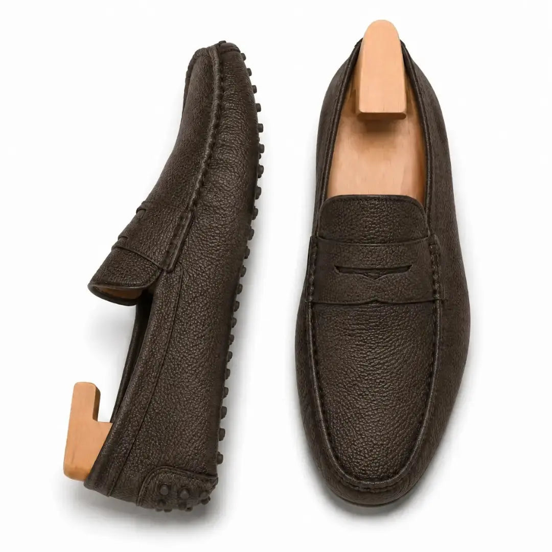 Dark brown leather penny loafer, three-quarter angle showing sole detailing