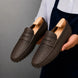 Man holding a pair of Melodiapelle Manhattan Loafers in dark brown leather, close-up
