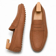 Rust tan leather penny loafer, three-quarter angle showing sole detailing