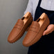 Man holding a pair of Melodiapelle Manhattan Loafers in rust tan leather, close-up