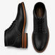 Black leather plain-toe boot, three-quarter angle showing heel and contrast stitching
