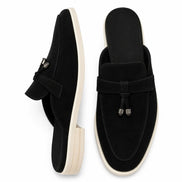 Black suede tassel mule loafer, three-quarter angle showing tassel and heel
