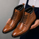 Man holding a pair of Melodiapelle Manteca Combat Boots in tan leather, close-up