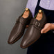 Man holding a pair of Melodiapelle Mapple Monkstrap shoes in dark brown leather, close-up