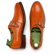 Tan leather single monk strap shoe, three-quarter angle showing heel and sole detailing