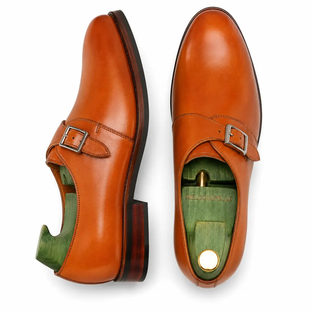 Tan leather single monk strap shoe, three-quarter angle showing heel and sole detailing