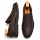 Brown embossed leather slip-on sneaker, three-quarter angle showing heel and woven texture