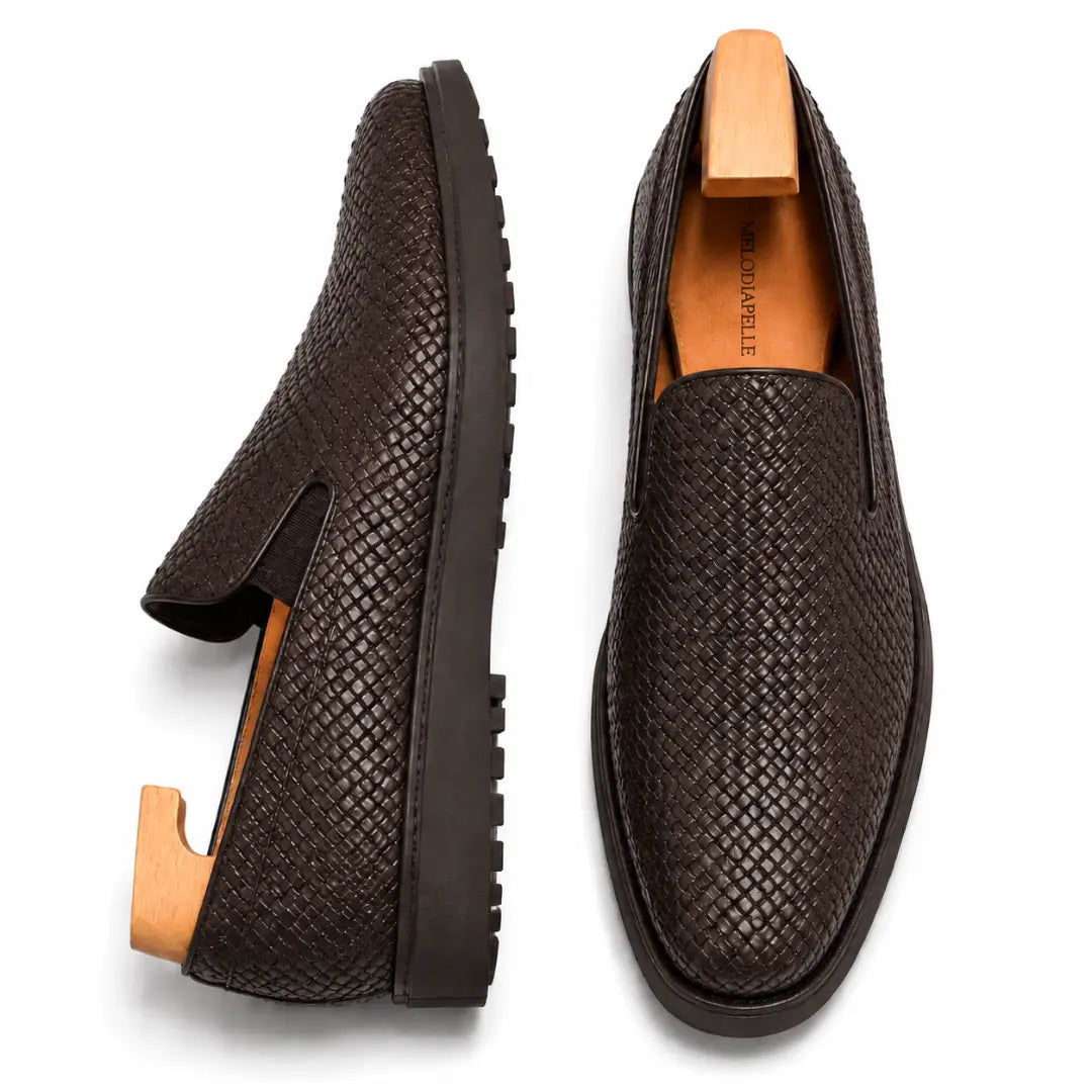 Brown embossed leather slip-on sneaker, three-quarter angle showing heel and woven texture