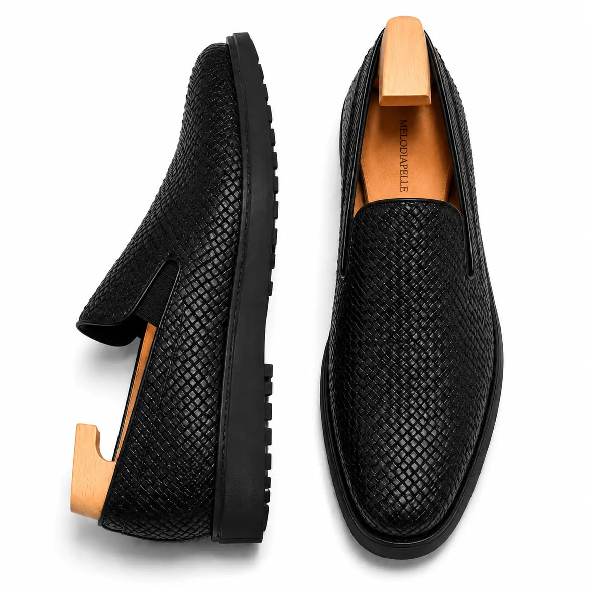 Nero black embossed leather slip-on sneaker, three-quarter angle showing heel and woven texture