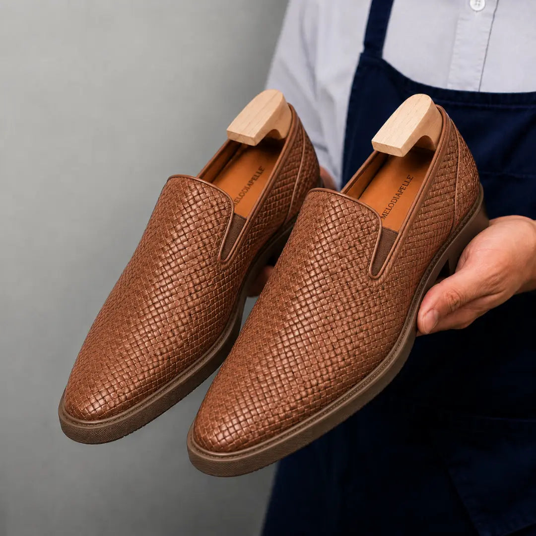 Man holding a pair of Melodiapelle Marengo Embossed Slip-On Sneakers in tan leather, close-up