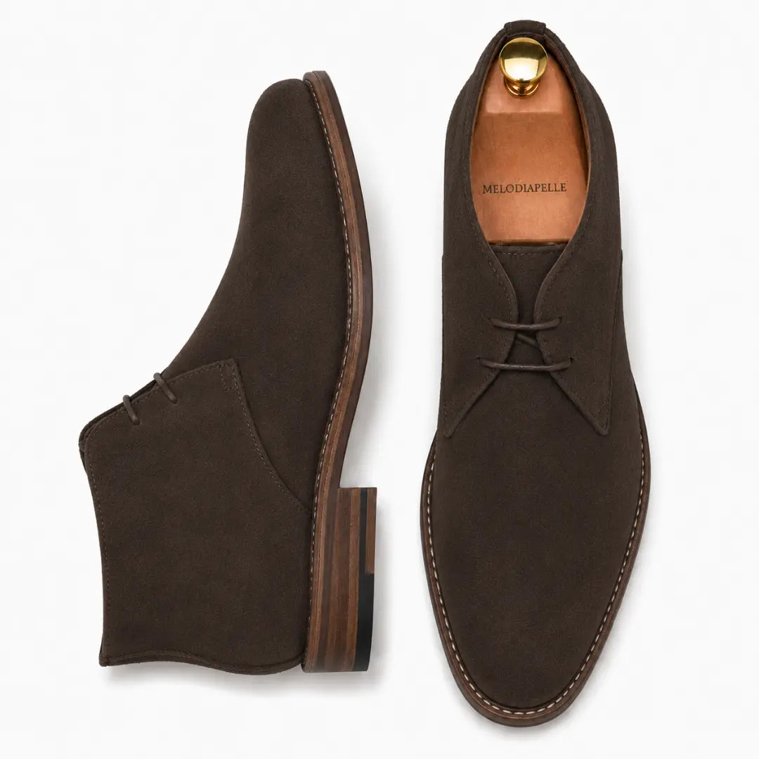 Dark brown suede chukka boot, three-quarter angle showing heel and sole detailing