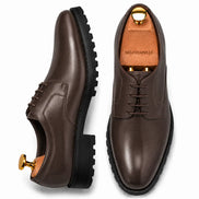 Dark brown leather plain-toe Derby, three-quarter angle showing heel and sole detailing