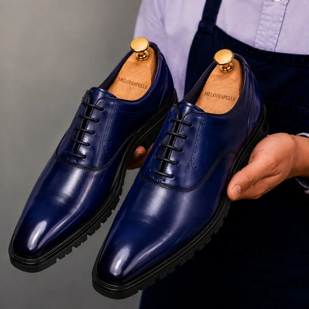 Man holding a pair of Melodiapelle Marlboro Derby Shoes in navy blue leather, close-up