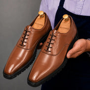 Man holding a pair of Melodiapelle Marlboro Derby Shoes in tan leather, close-up