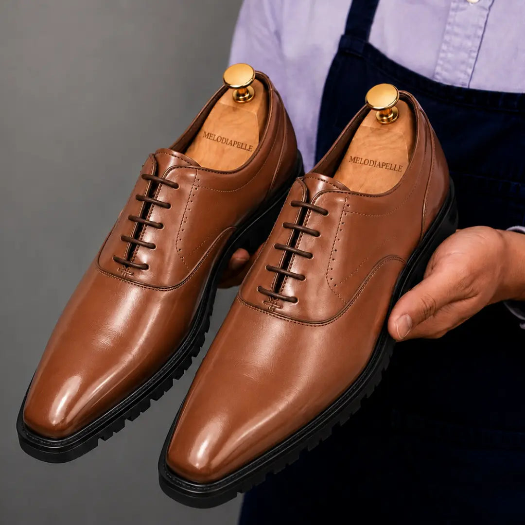 Man holding a pair of Melodiapelle Marlboro Derby Shoes in tan leather, close-up