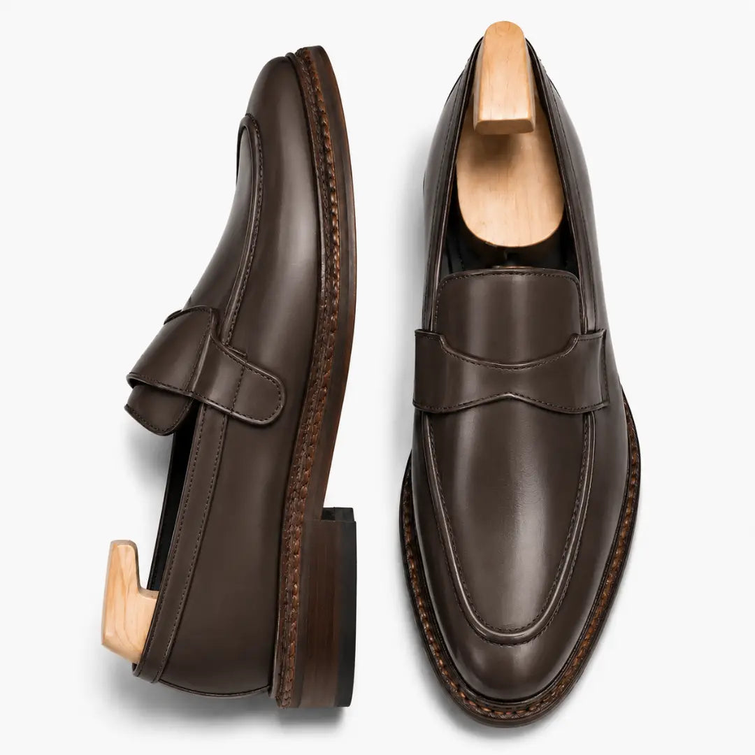 Brown leather dress penny loafer, three-quarter angle showing heel and penny strap